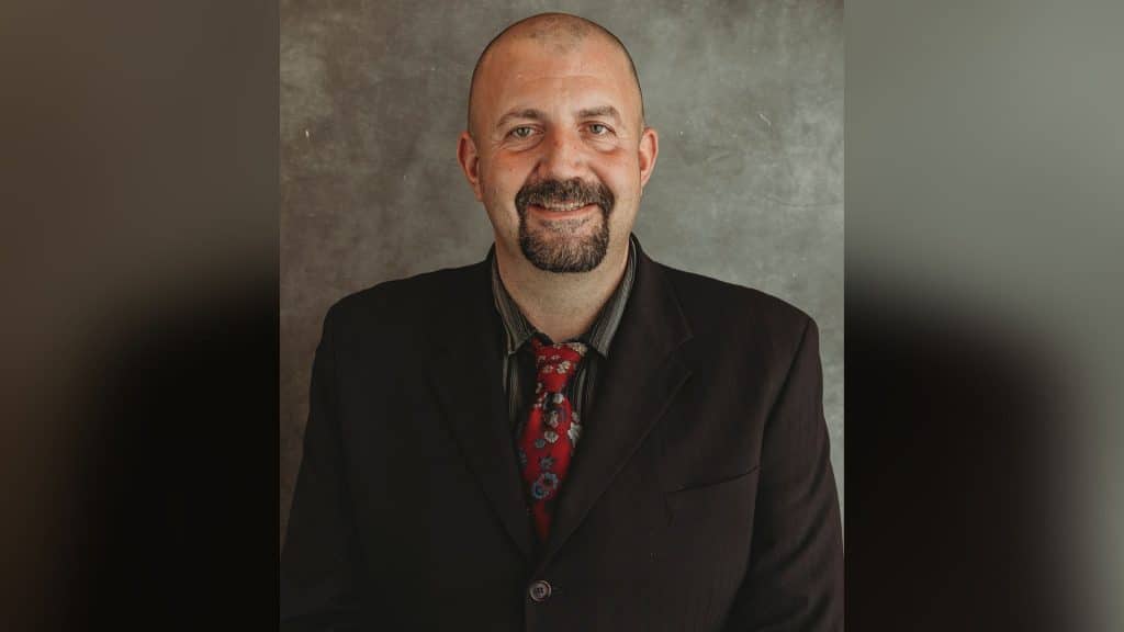 A bald middle aged man in a suit.