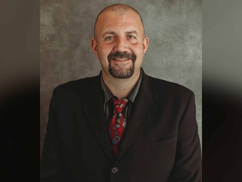 A bald middle aged man in a suit.