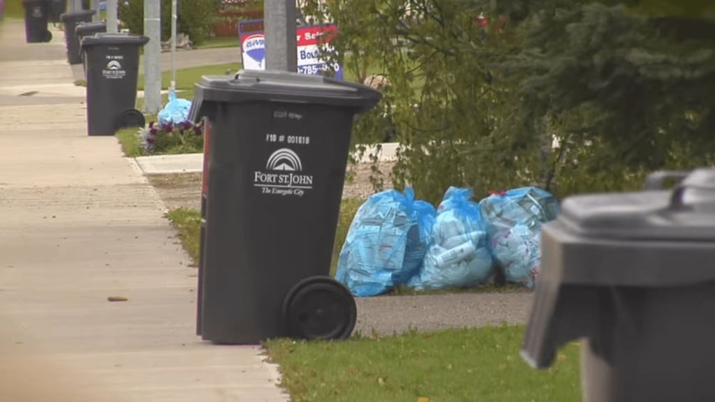 City of Fort St. John garbage cans in a row on a sidewalk.