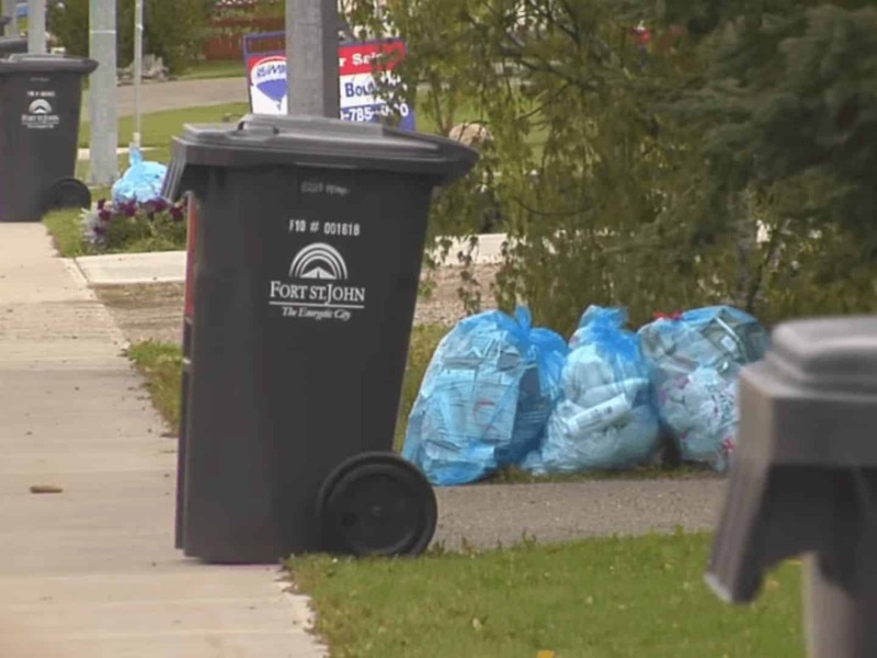 City of Fort St. John garbage cans in a row on a sidewalk.