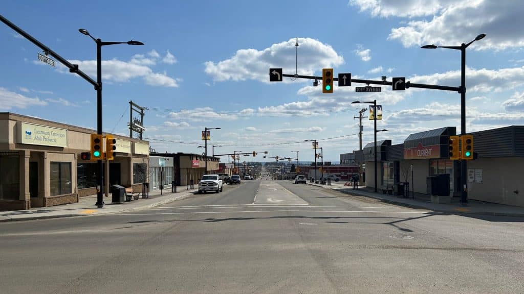 A picture of a street with businesses on either side and a green traffic light.