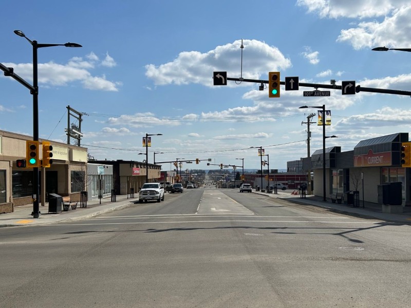 A picture of a street with businesses on either side and a green traffic light.