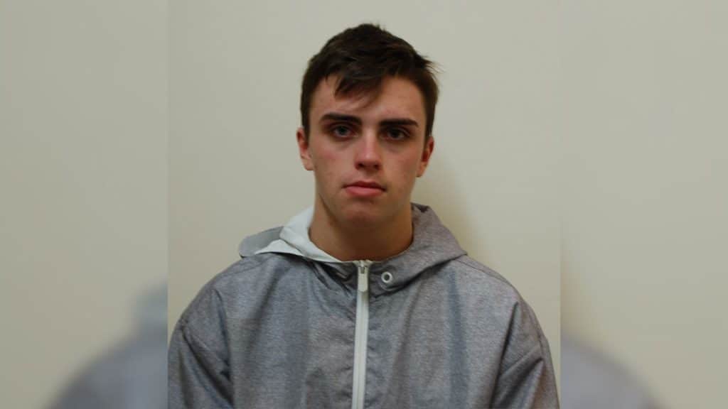 A picture of a young man in a grey jacket in front of a light background.