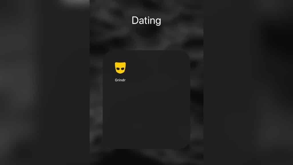 A screen shot of a phone screen with the dating app Grindr in a folder titled Dating.