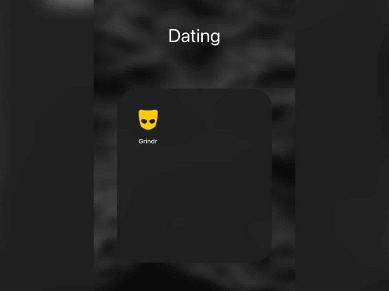 A screen shot of a phone screen with the dating app Grindr in a folder titled Dating.