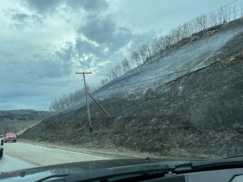 A burned hillside beside a highway.