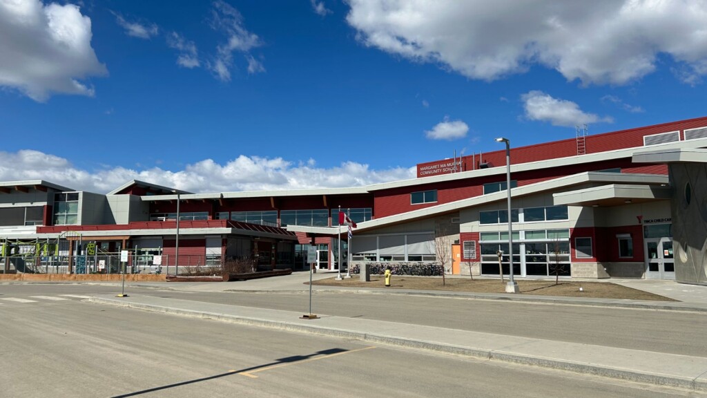 A picture of a red and white school with a Canadian flag in the front.