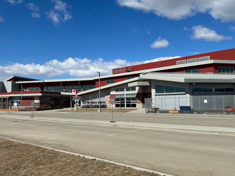 A picture of a red and white school with a Canadian flag in the front.