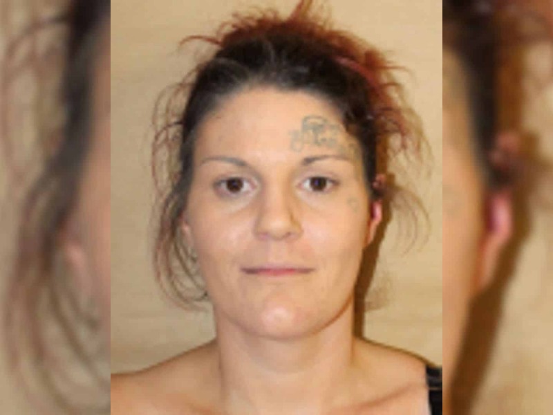 A photo of a girl with a tattoo above and below her right eye and her hair pinned up.