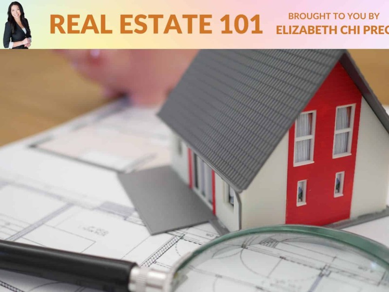 A model of a house next to a magnifying glass