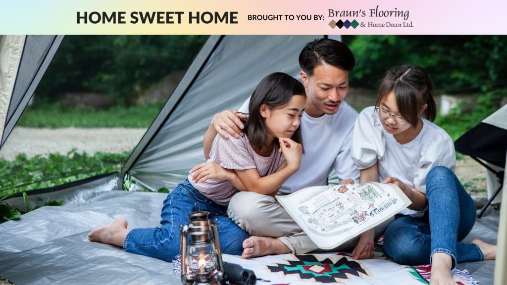 A family sitting in a tent staring at a map
