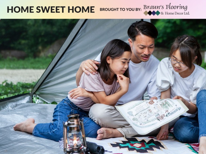 A family sitting in a tent staring at a map