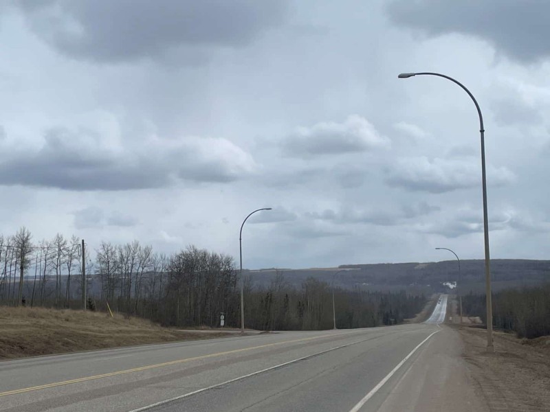 A picture of the Alaska Highway under a cloudy sky.