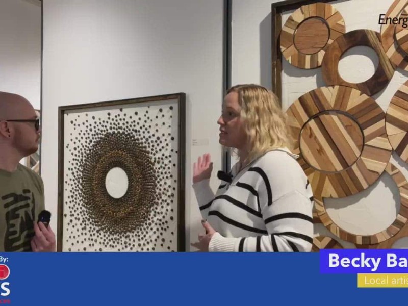 Two people talking in front of an art exhibit