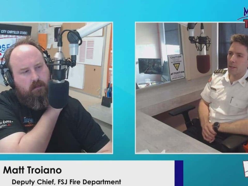 Two people talking behind microphones