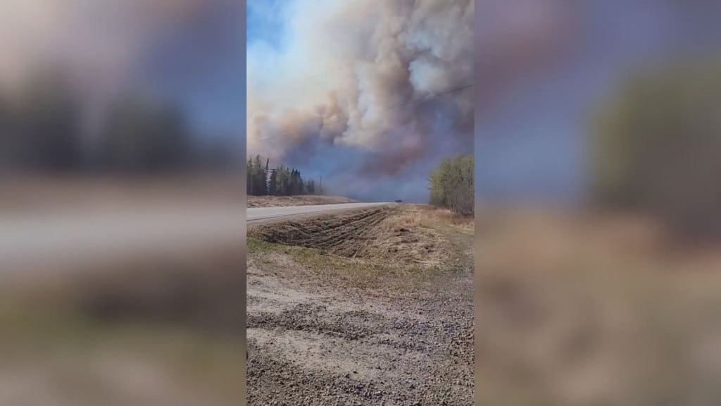 A picture of a highway with trees next to it on fire.