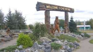 A wooden Welcome to Chetwynd sign with carved wooden bears.