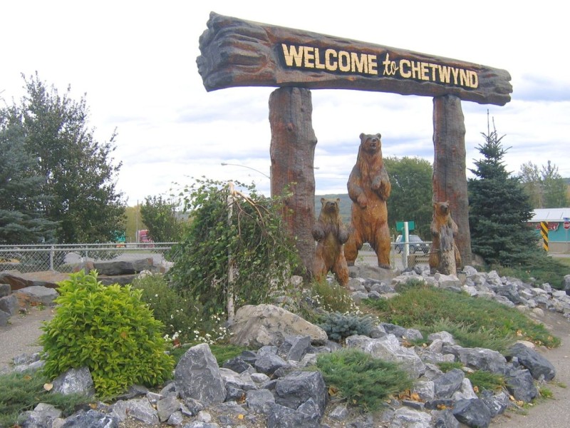A wooden Welcome to Chetwynd sign with carved wooden bears.