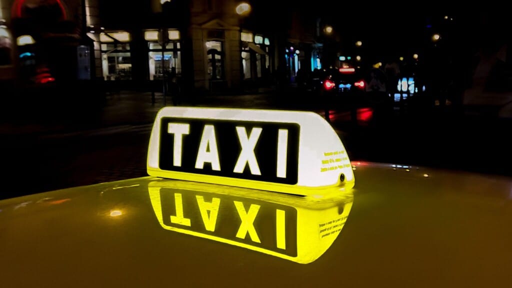 A yellow taxi light on at night.