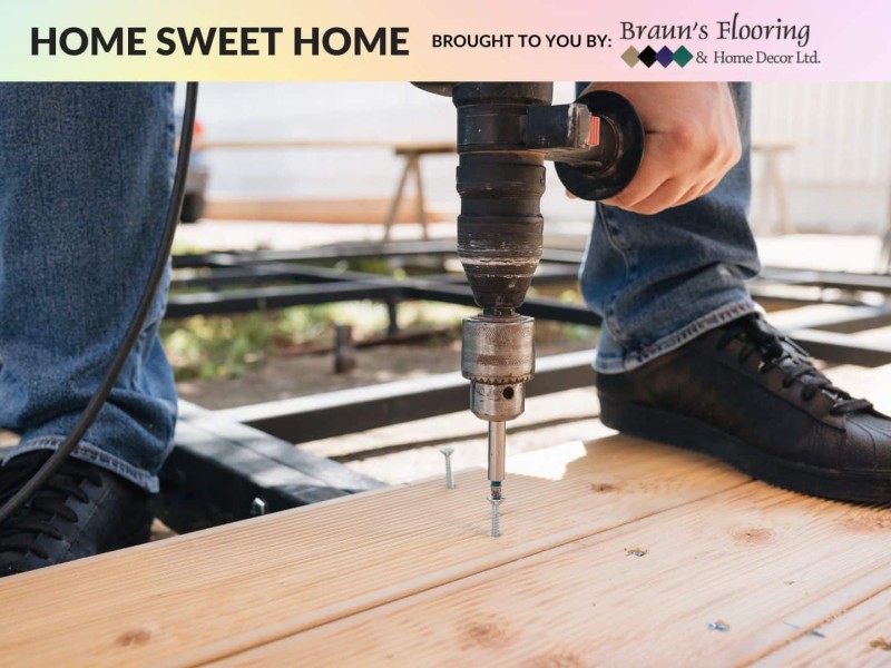 A person drilling into a floorboard