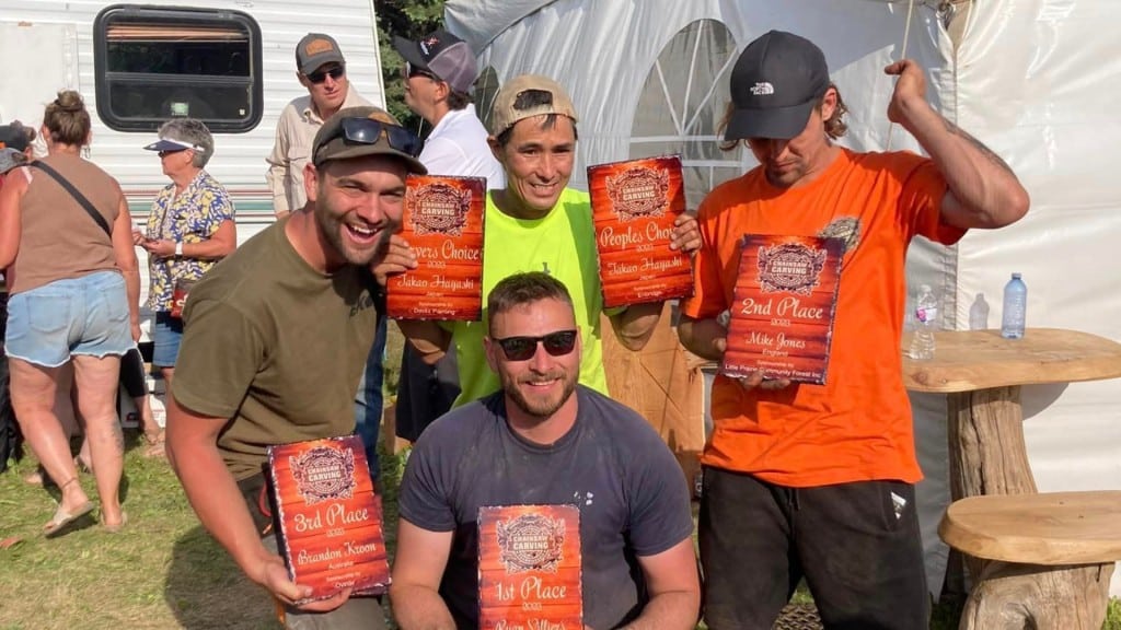 Four men holding awards for the chainsaw charving championship in Chetwynd.