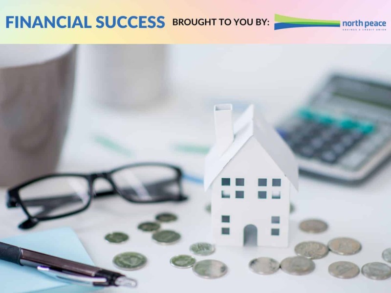 A model of a house sitting on a pile of coins