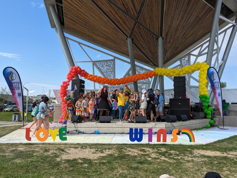 A stage in Centennial Park with Love Wins in front of it and a large group of people on the stage.
