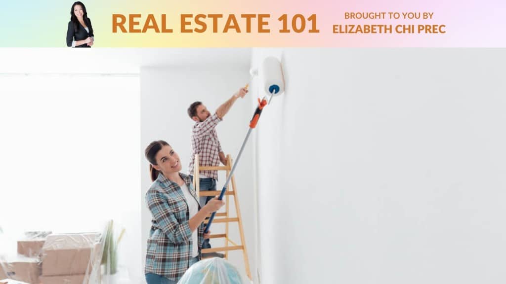 Two people painting a wall