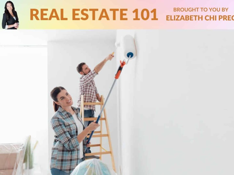 Two people painting a wall