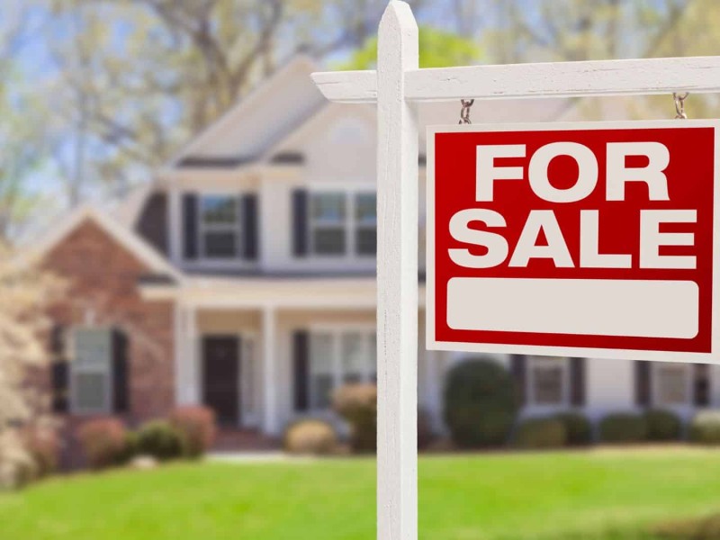 A for sale sign outside of a house. (Canva)