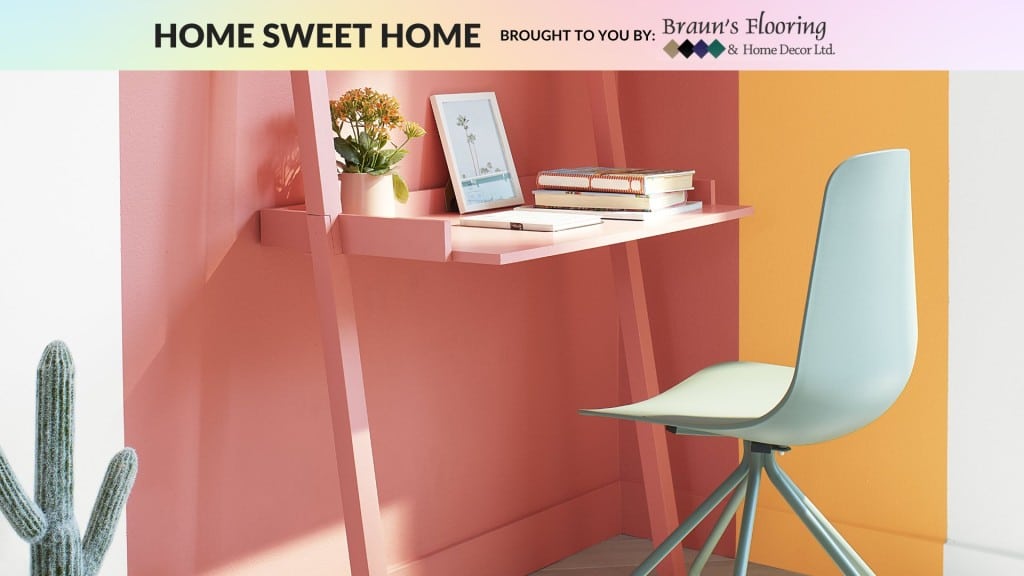 A small desk with a white chair and multi-coloured walls