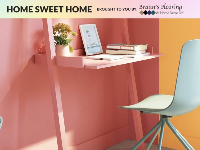 A small desk with a white chair and multi-coloured walls