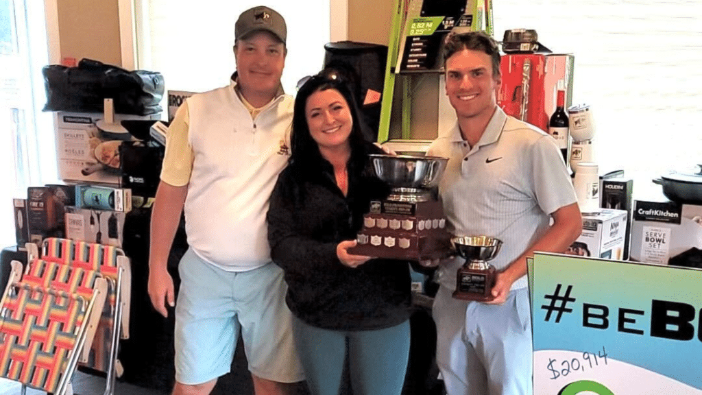 Three people smiling at the camera, two of them holding trophies