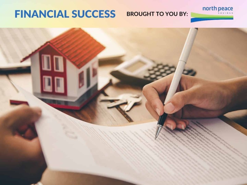 A model of a house on a table as people go over a contract