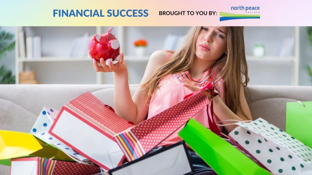 A person covered in shopping bags looking concerned at their piggy bank