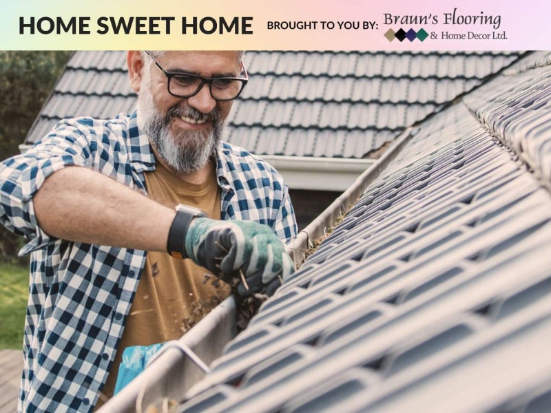 A person cleaning out the gutters of their house