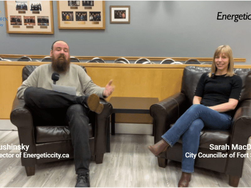 Two people sitting in chairs smiling at the camera