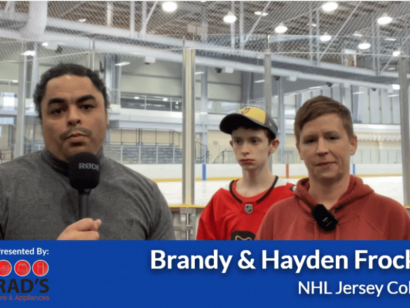 Three people in an ice rink looking at the camera