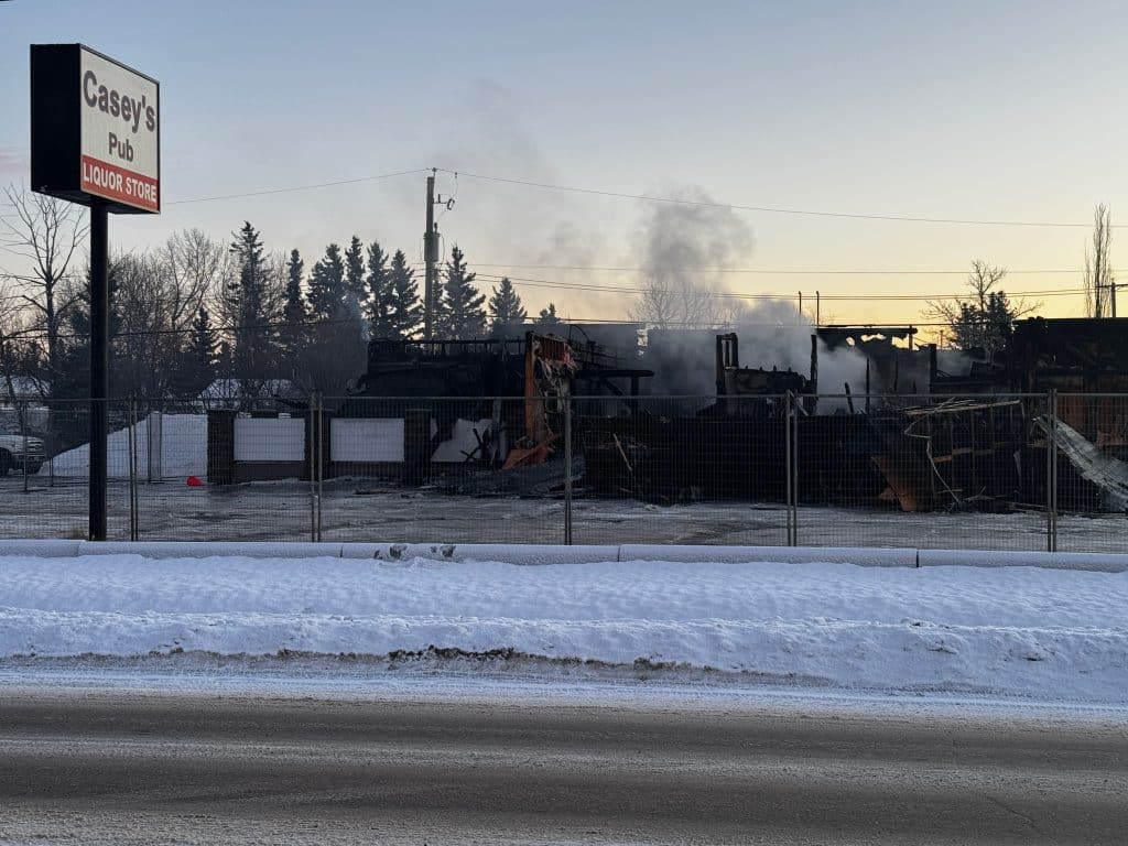 The photo shows the aftermath of a fire at Casey's Pub in Fort St. John. The building was destroyed by the fire.