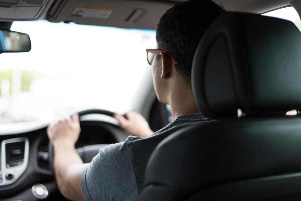 File photo of a driver in a car, man with hand on steering wheel