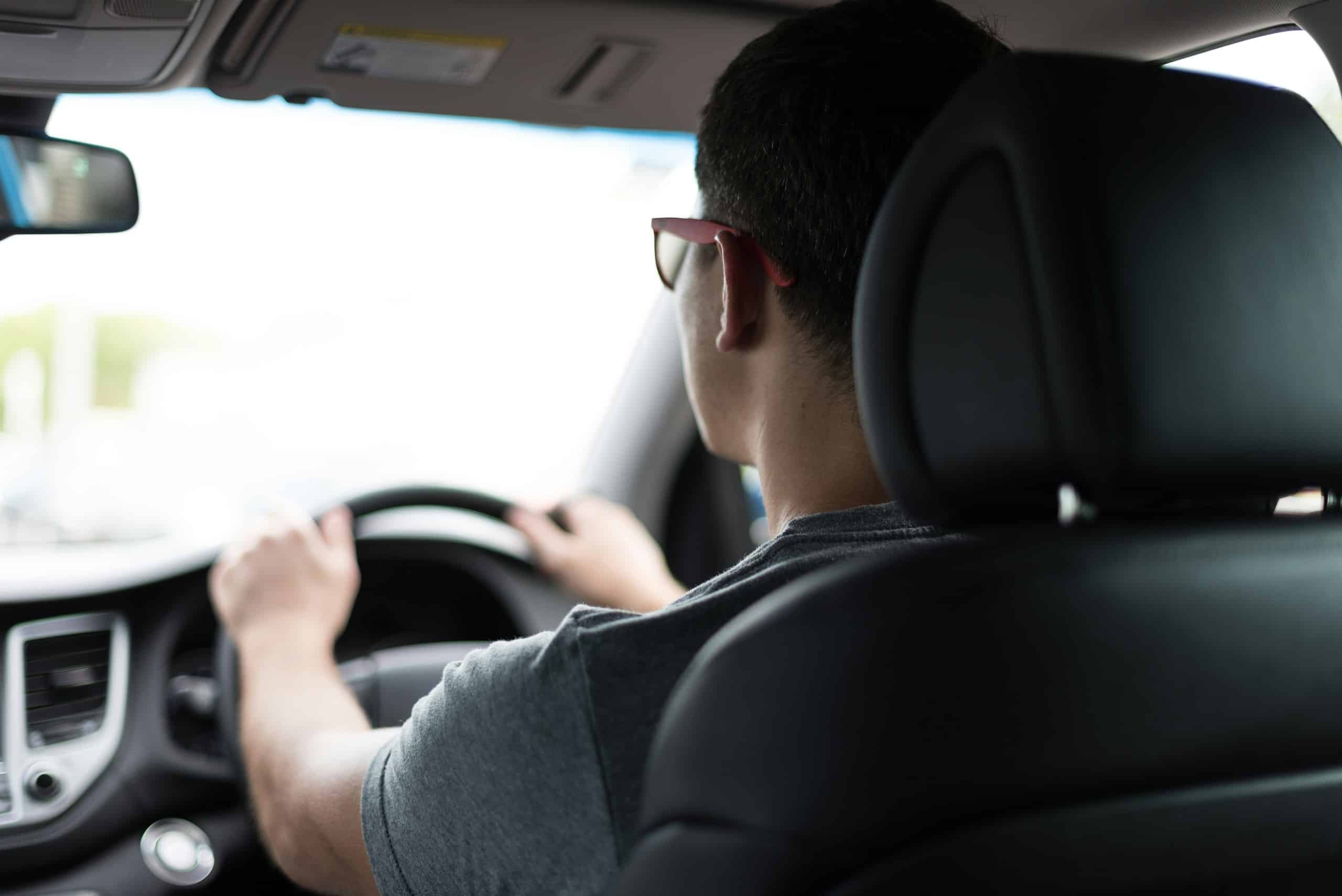 File photo of a driver in a car, man with hand on steering wheel