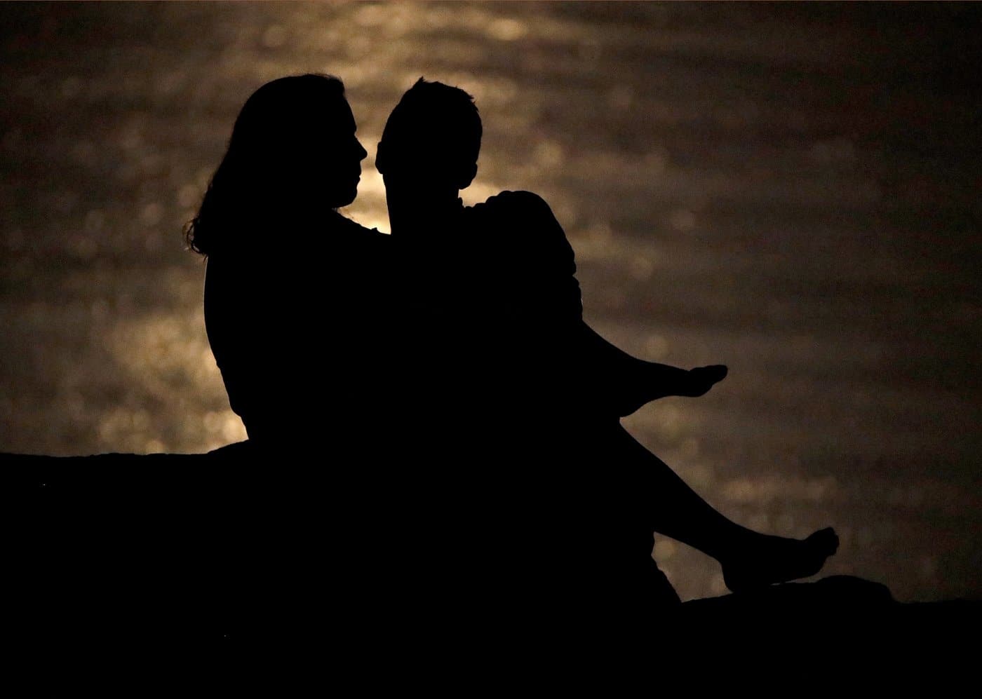 A couple is silhouetted against moonlight reflecting off the Missouri River in Kansas City, Mo. on June 27, 2018. THE CANADIAN PRESS/AP/Charlie Riedel