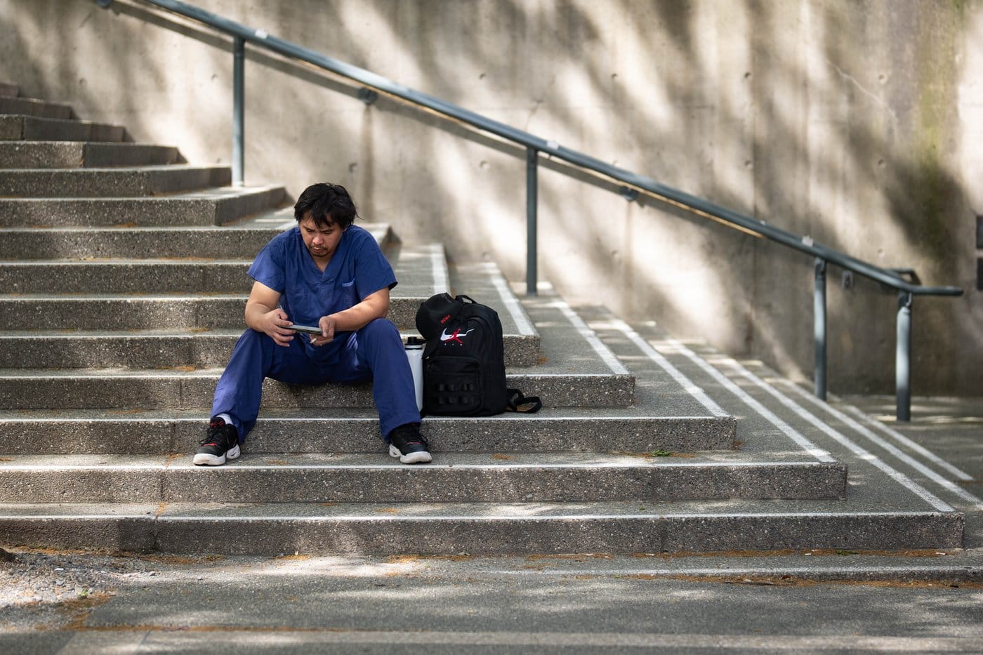 A hospital worker sits outside of the Vancouver General Hospital in Vancouver, B.C., on Tuesday, May 12, 2026. THE CANADIAN PRESS/Ethan Cairns