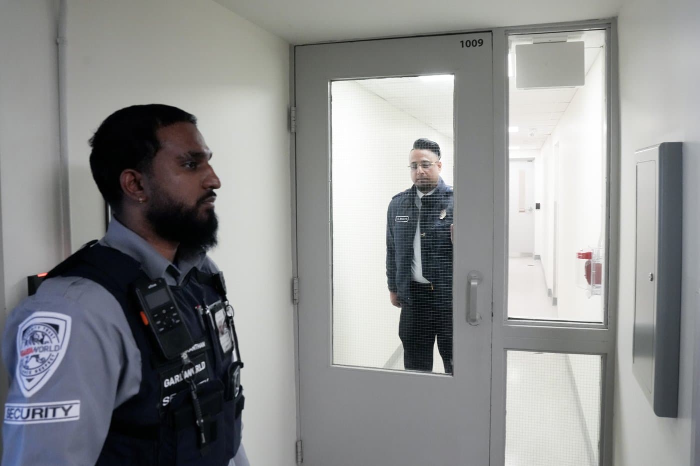 A Canada Border Services Agency staff member walks towards a security guard at the CBSA's GTA Immigration Holding Centre in Toronto, Wednesday, Feb. 19, 2025. THE CANADIAN PRESS/Chris Young