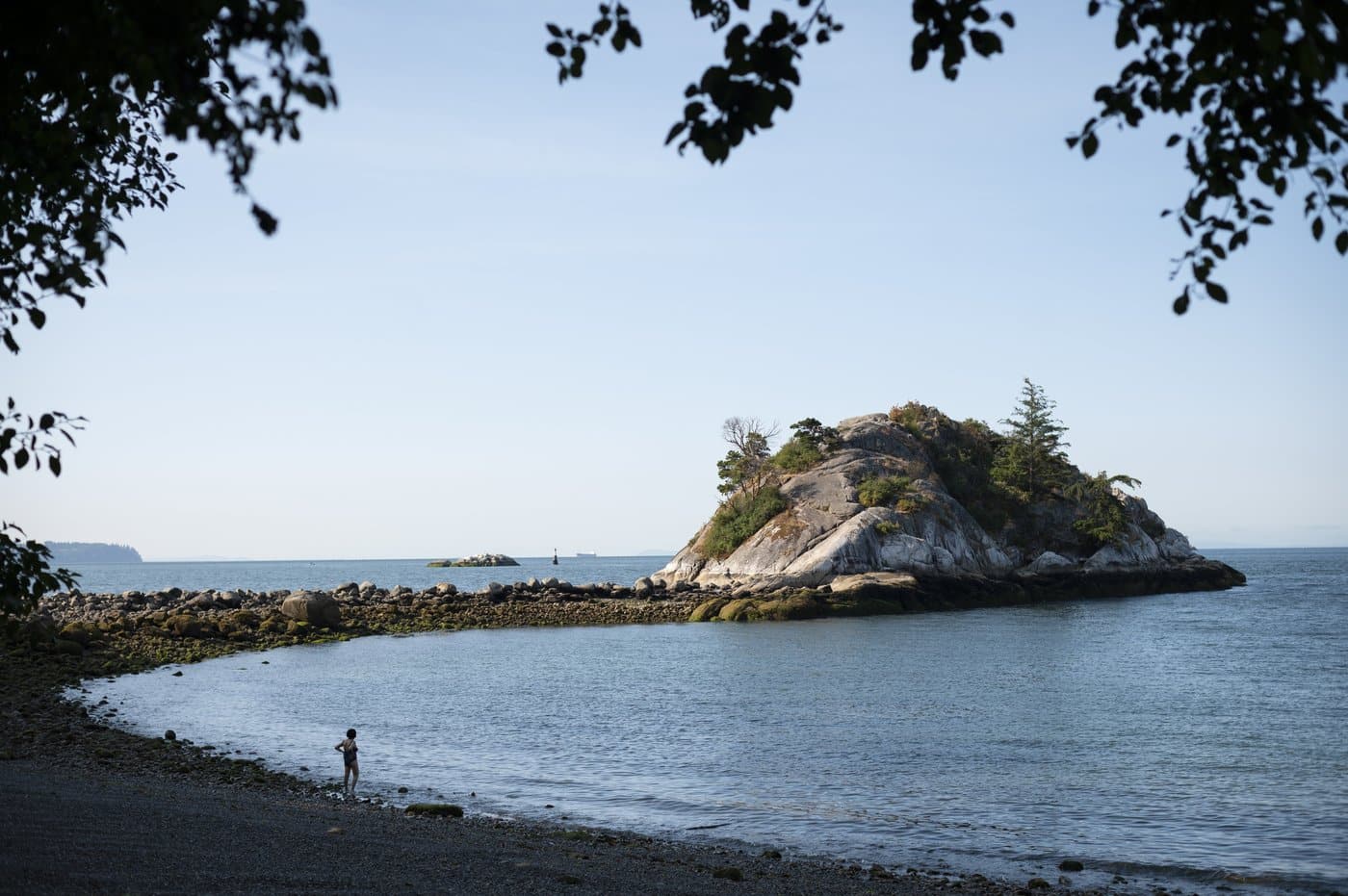A swimmer stands along the shoreline at Whytecliff Park in West Vancouver, B.C., on Thursday, July 18, 2024. THE CANADIAN PRESS/ Tijana Martin
