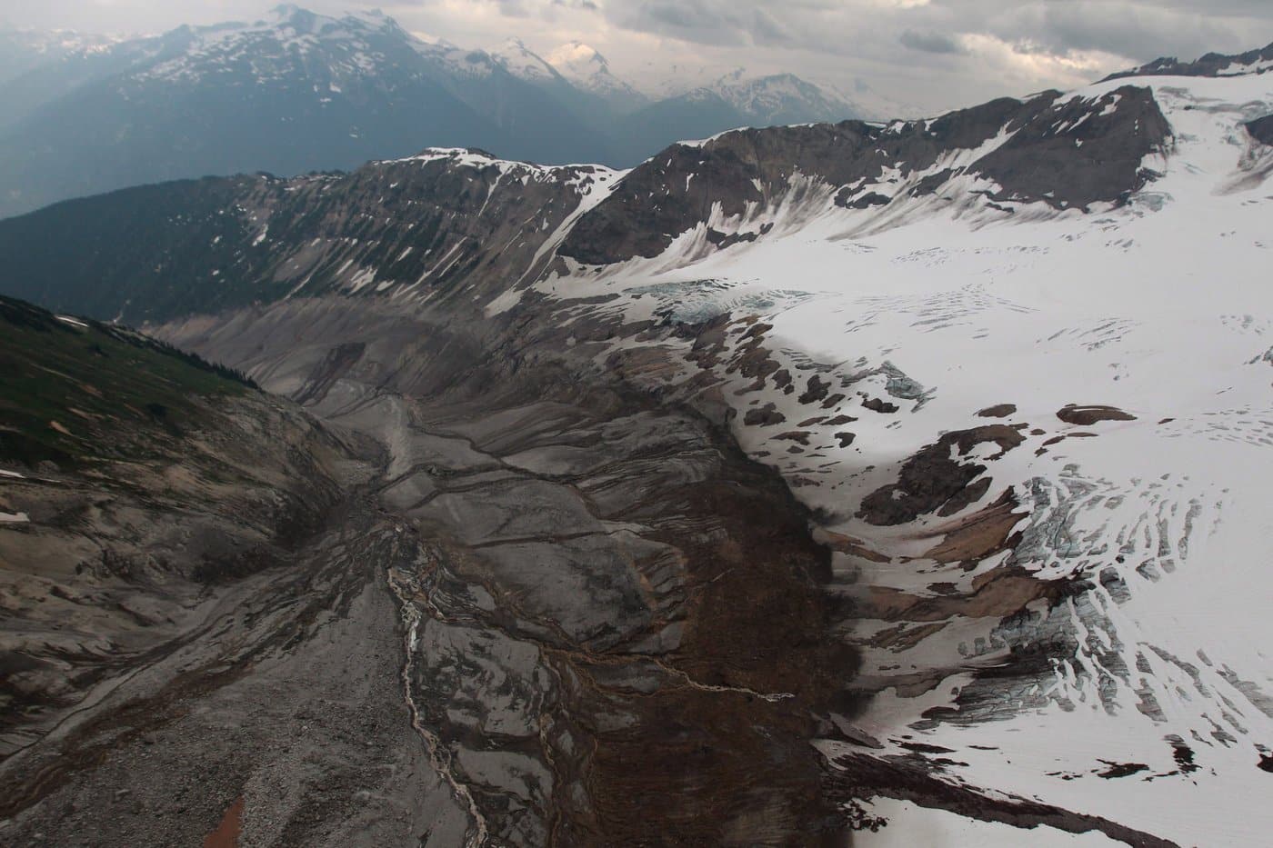 Looking down from the top of the mountain, a portion of a glacier, right, is visible as water continues to flow down the debris field, left, after a landslide occurred near Meager Creek Hot Springs north of Pemberton, B.C., on Friday Aug. 6, 2010. THE CANADIAN PRESS/Darryl Dyck