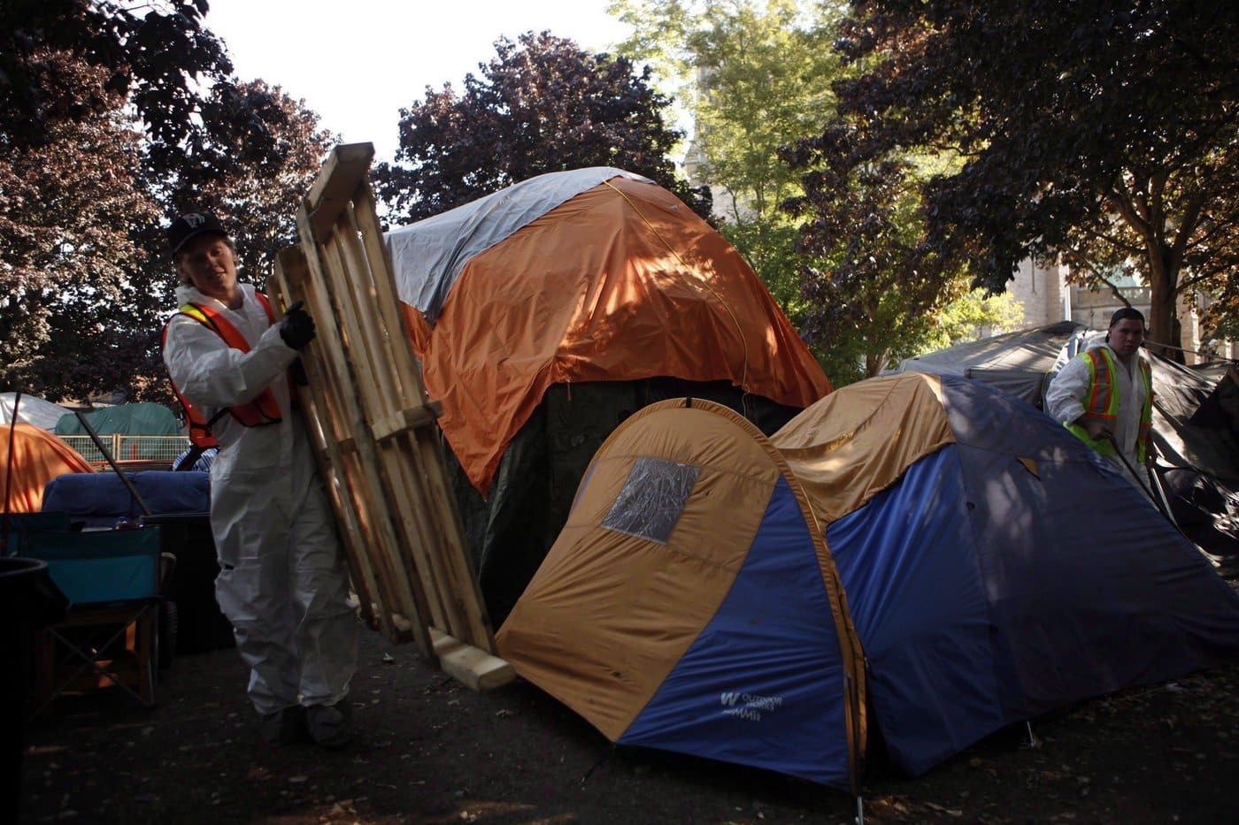 Workers from a hazmat company dismantle vacant tents remaining at tent city on the courthouse lawn in Victoria, B.C., Monday, Aug. 8, 2016. THE CANADIAN PRESS/Chad Hipolito