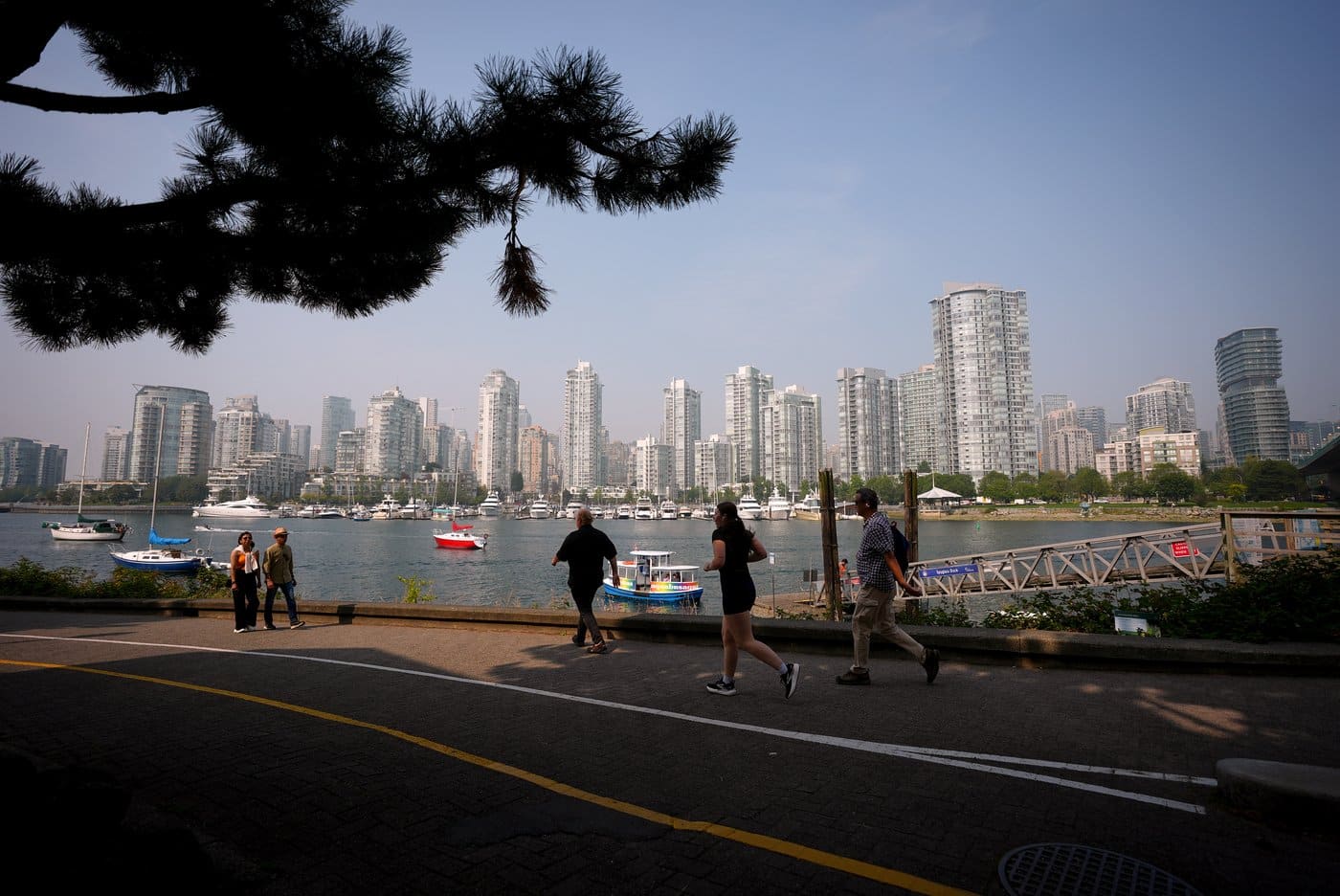 People walk and jog on the False Creek seawall in Vancouver, B.C., Wednesday, Sept. 3, 2025. THE CANADIAN PRESS/Darryl Dyck