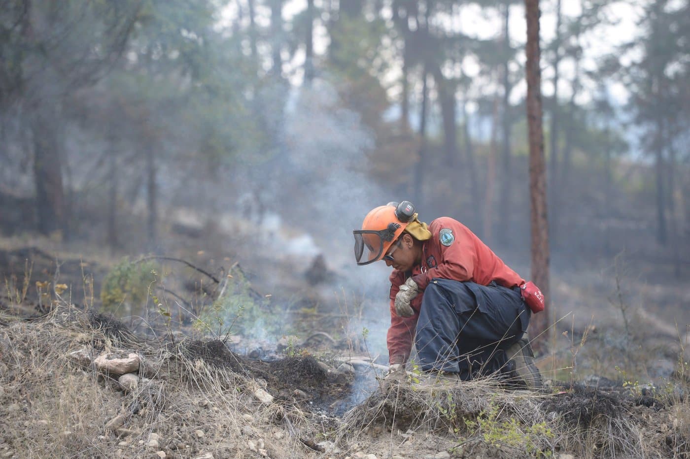A firefighter works on a wild fire burning in West Kelowna, B.C. Wednesday, July 23, 2015. THE CANADIAN PRESS/Jonathan Hayward