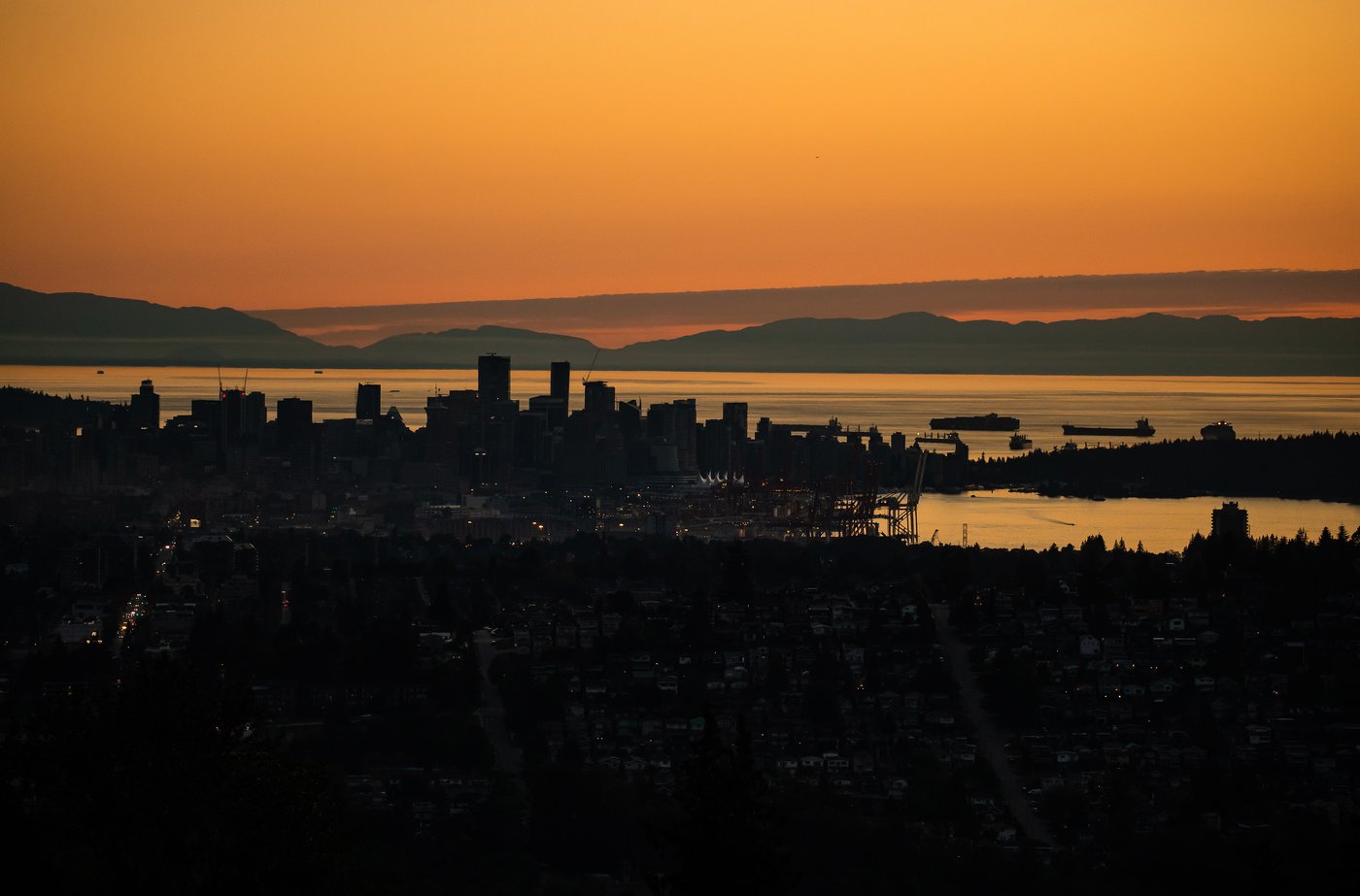 The downtown Vancouver skyline is silhouetted at sunset on Monday, July 11, 2022. THE CANADIAN PRESS/Darryl Dyck